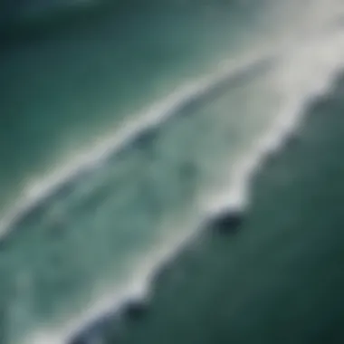 Aerial view of surfers catching waves in a crystal-clear ocean