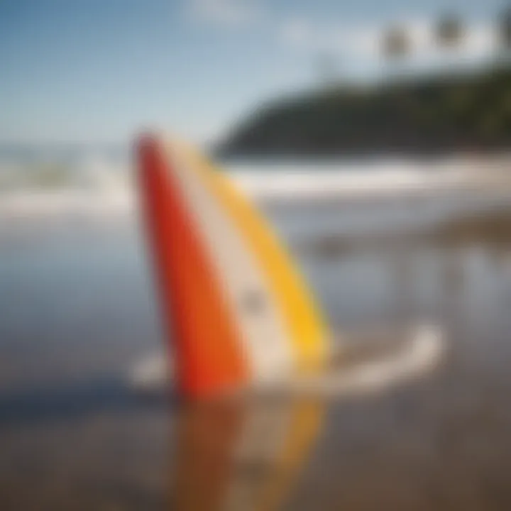 Close-up of surfboard fins on a sandy beach with crystal clear waves in the background