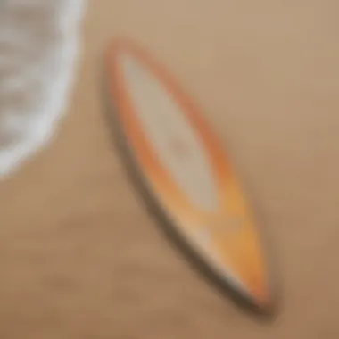 A top view of the sleek surfboard on a sandy beach