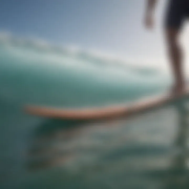 Male surfer standing on surfboard with sandals visible