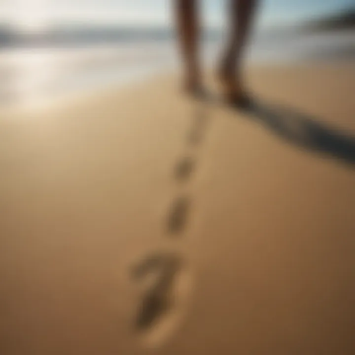 Footprints in the sand leading toward the ocean