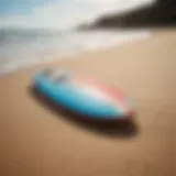 A vibrant skimmer board resting on the sandy beach.