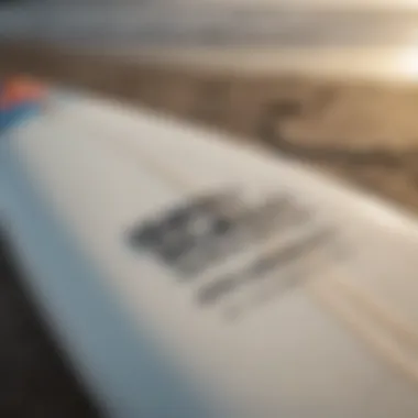 A close-up of a surfboard with a local surf school's branding.