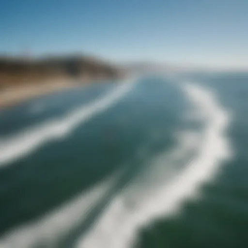 Aerial view of kiteboarders gliding through the waves under a clear blue sky in San Francisco