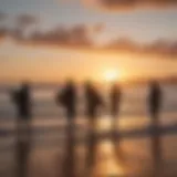 Silhouette of surfers carrying surfboards at sunrise