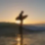 Sunset silhouette of a surfer with a longboard