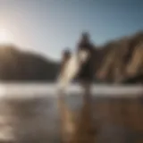 Surfer carrying surfboard on a rocky beach