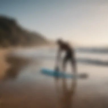 Surfer adjusting surfboard leash before heading into the water