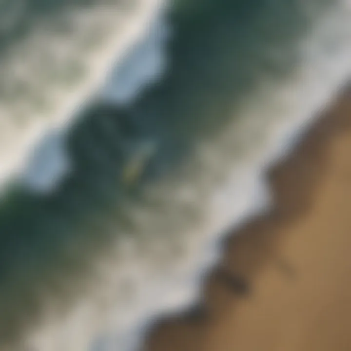 Aerial view of a surfers catching waves at a famous California beach