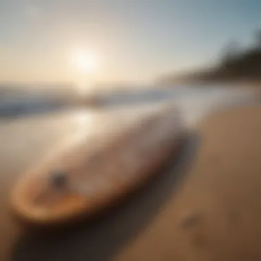 Surfboard with intricate wave design on a sandy shore